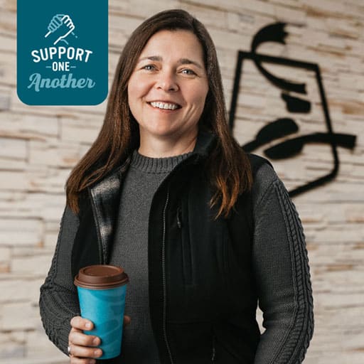 Headshot of Director of Construction Emily Heuring smiling and holding a cup of Caribou Coffee