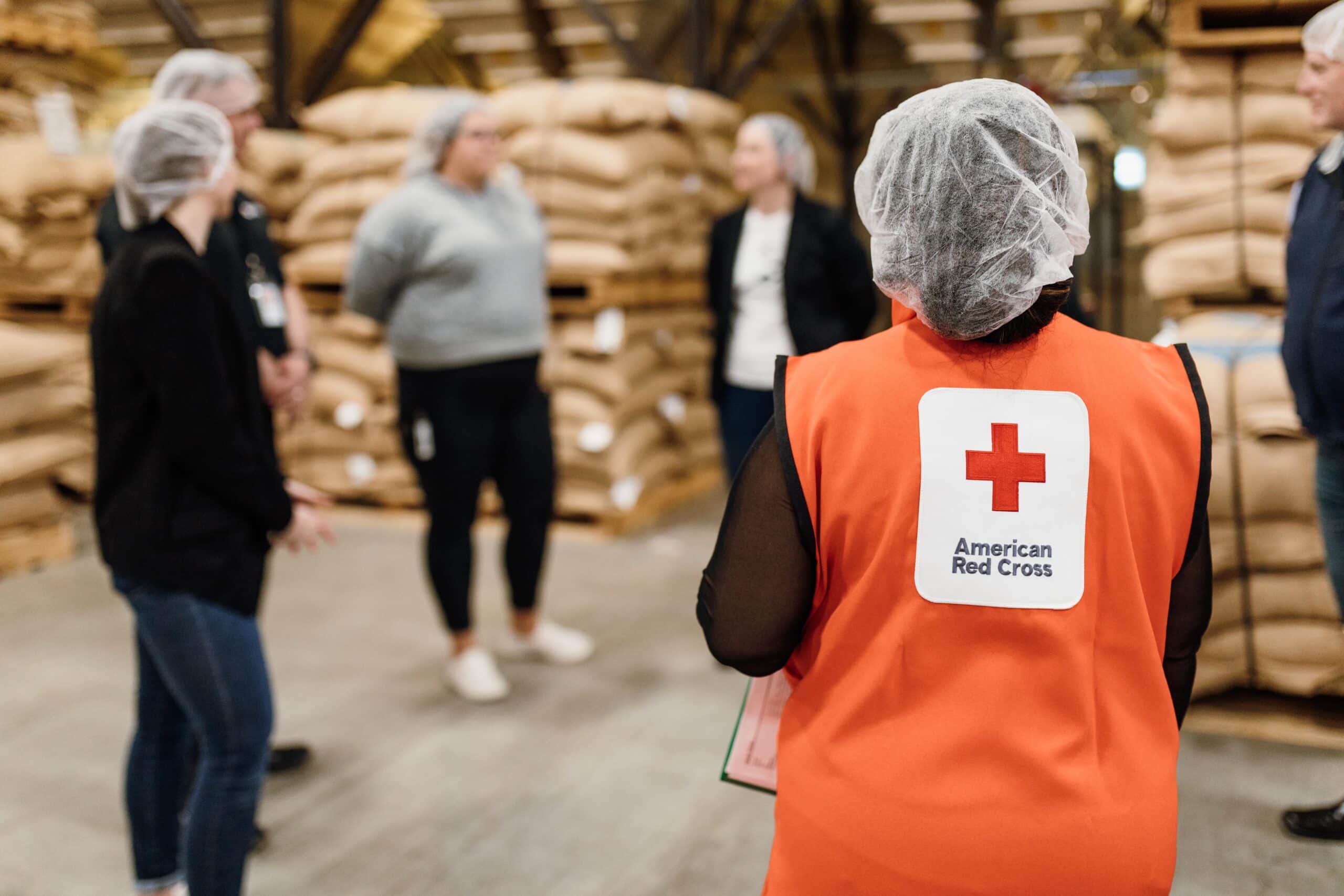 individuals with connections to the red cross standing in a circle with caribou coffee employees on a tour of the roastery at caribou coffee headquarters 