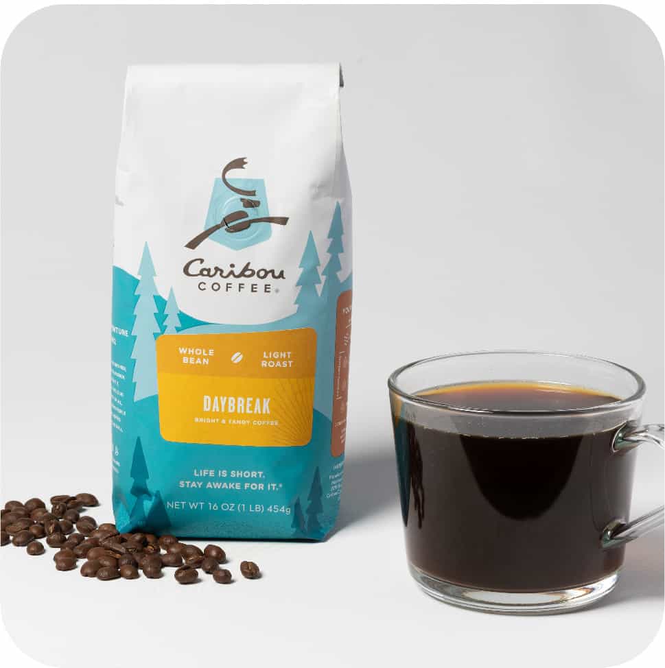 A bag of daybreak blend beans and a cup of coffee. Explore our coffee beans today.