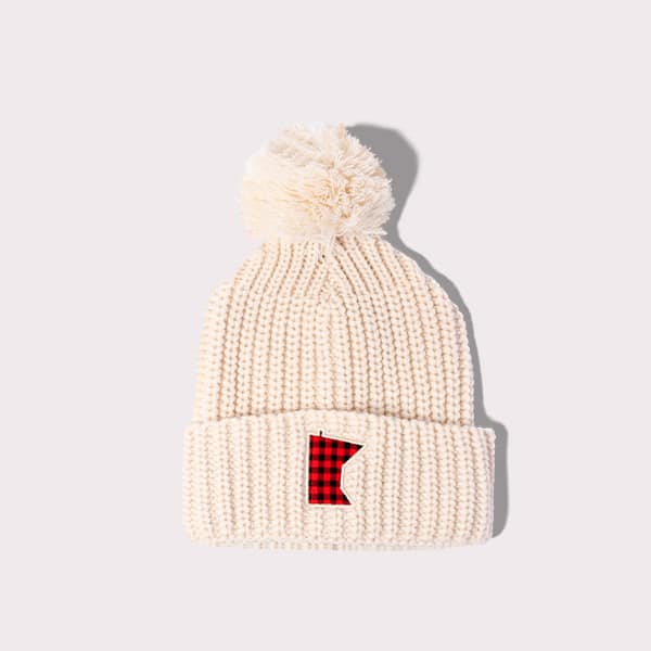 White beanie with a white puffball at the top and a minnesota design on the front