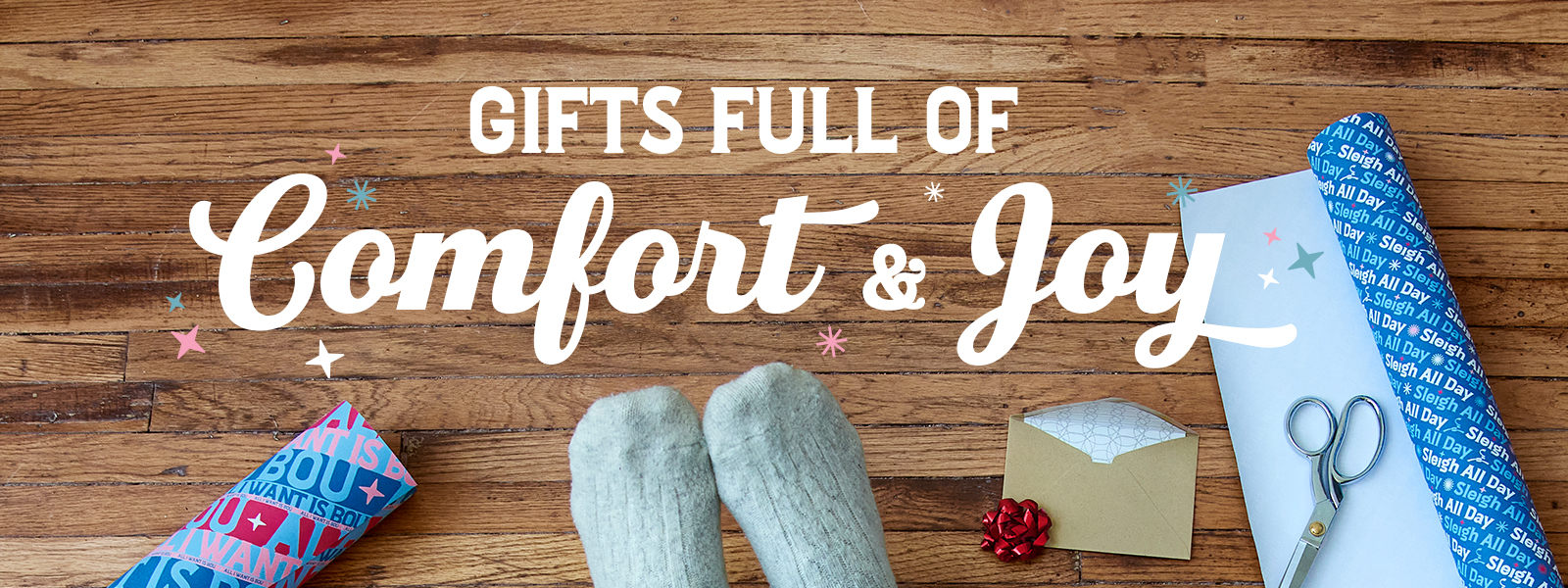 Gifts full of Comfort & Joy. Someone wrapping presents.