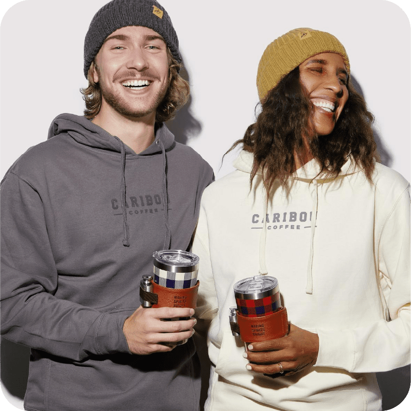 Two people smiling and holding drinkware