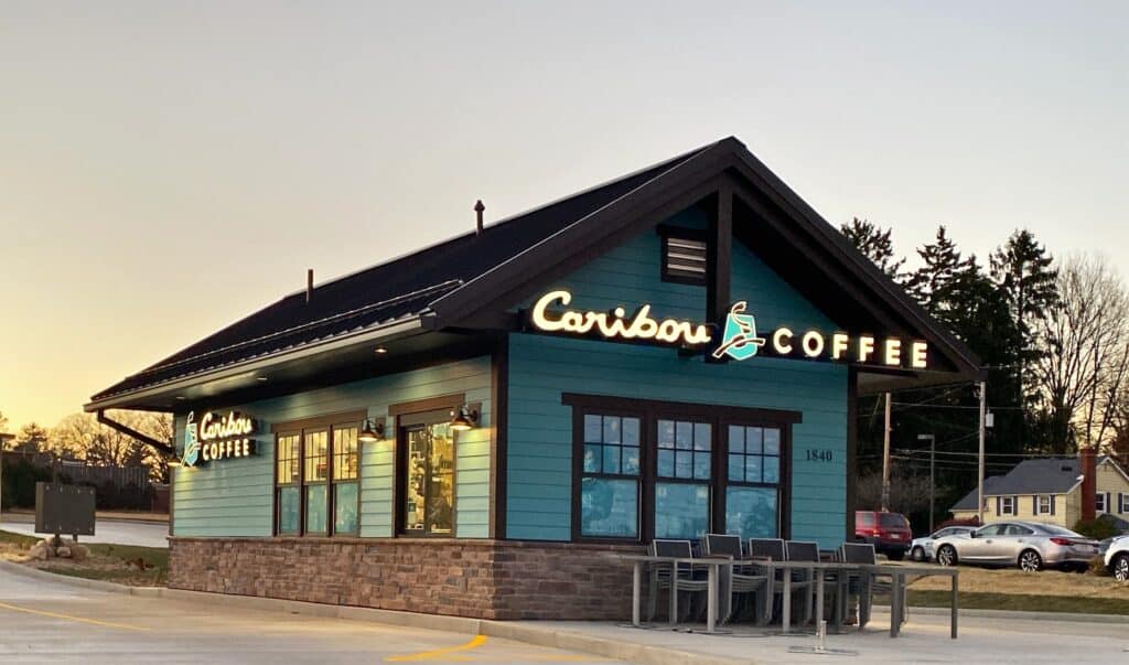 A blue building with a brown roof and a Caribou Coffee logo