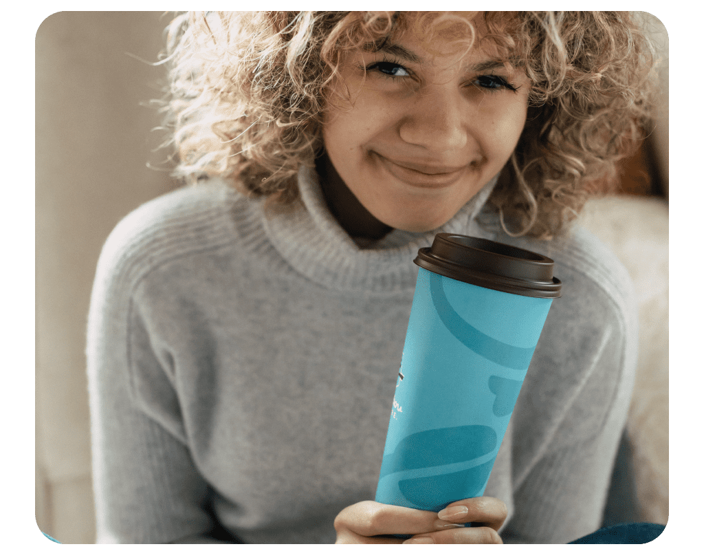 Woman smiling and holding a cup of coffee
