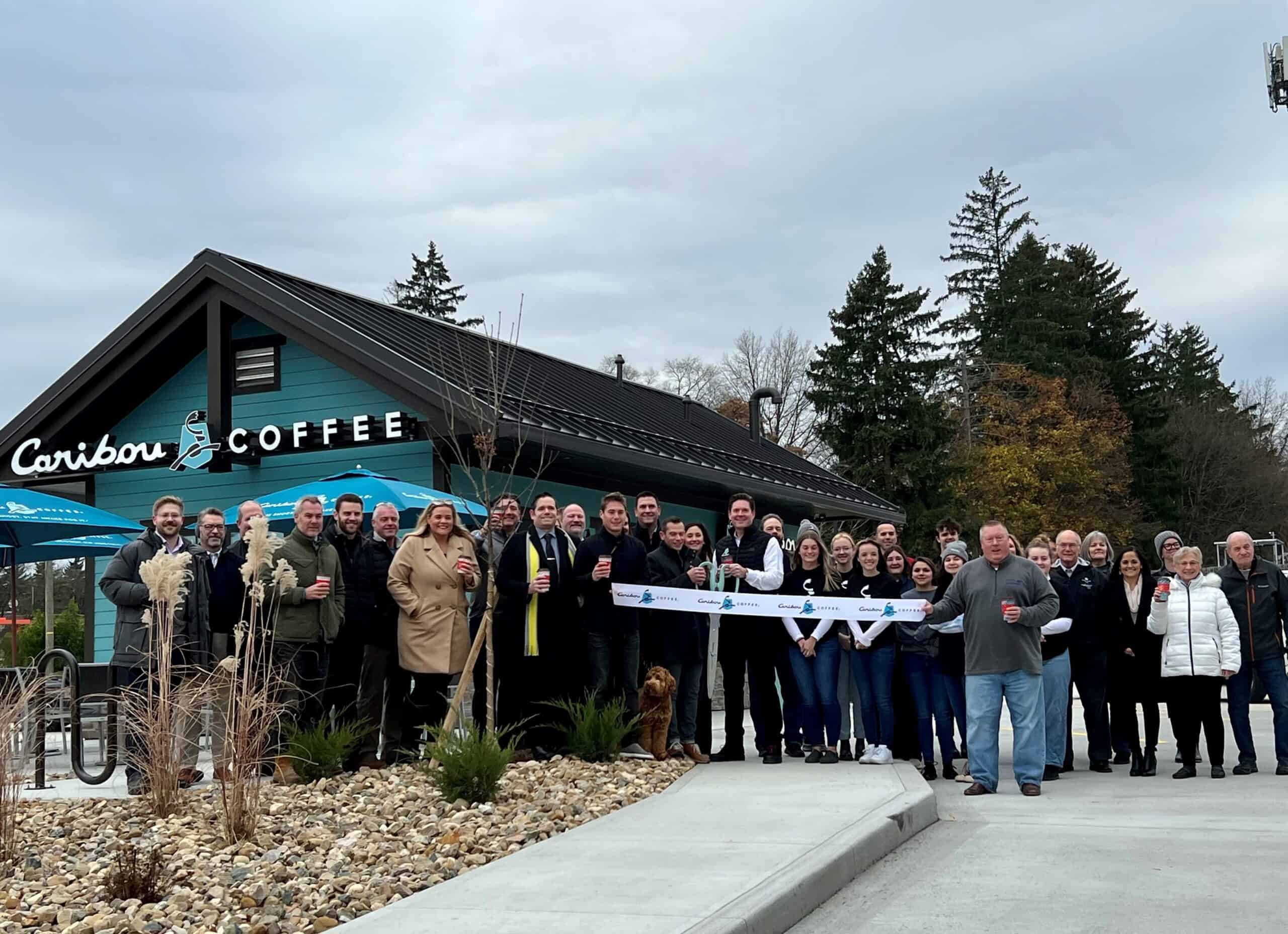 mike mariola restaurant team and caribou coffee team standing outside new caribou coffee cabin in wooster ohio for ribbon cutting ceremony