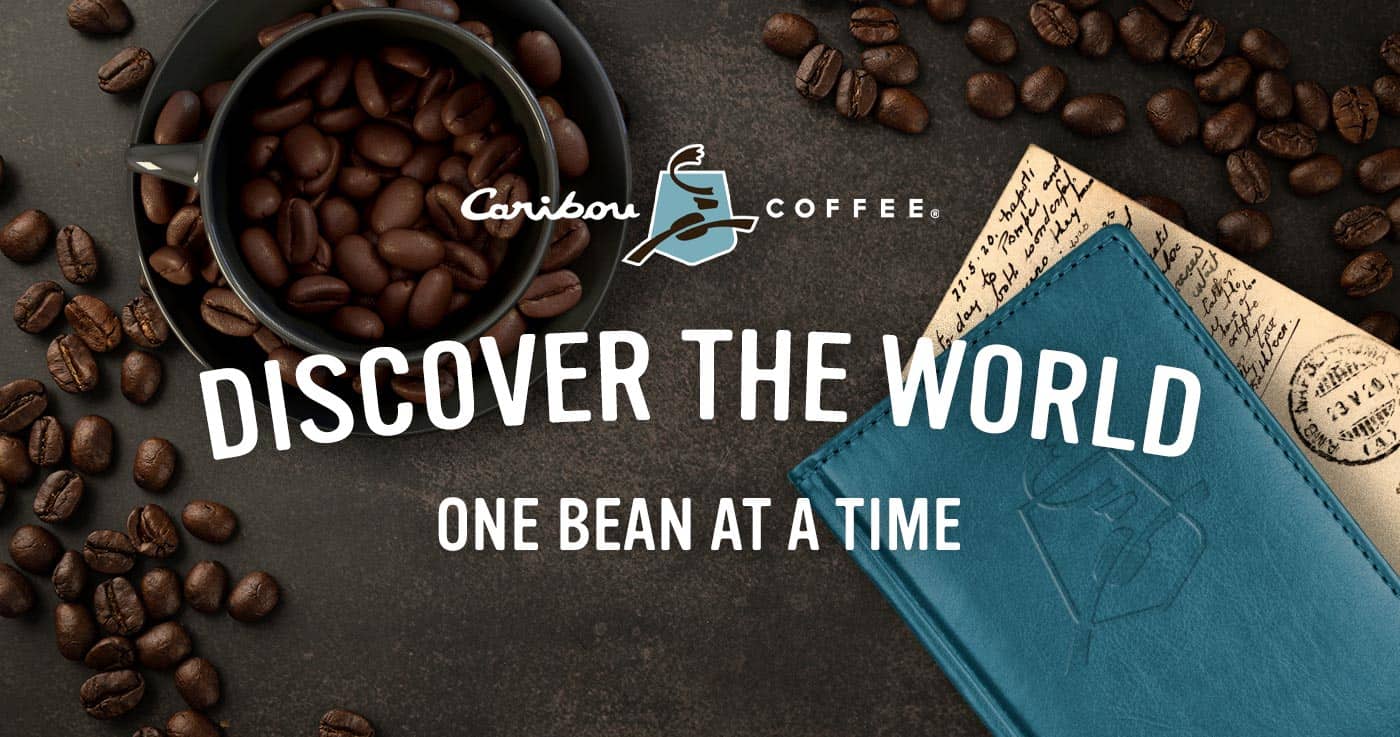 caribou branded passport next to a coffee mug overflowing with coffee beans