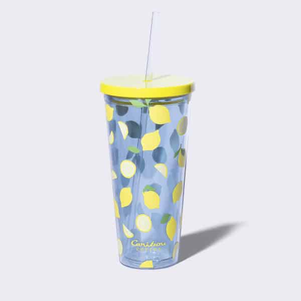 Clear tumbler with yellow lemons and a straw.