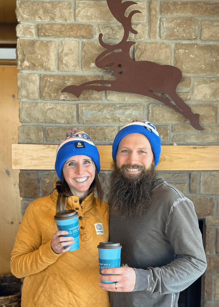kirstin and brian tracy smiling while holding caribou coffee 