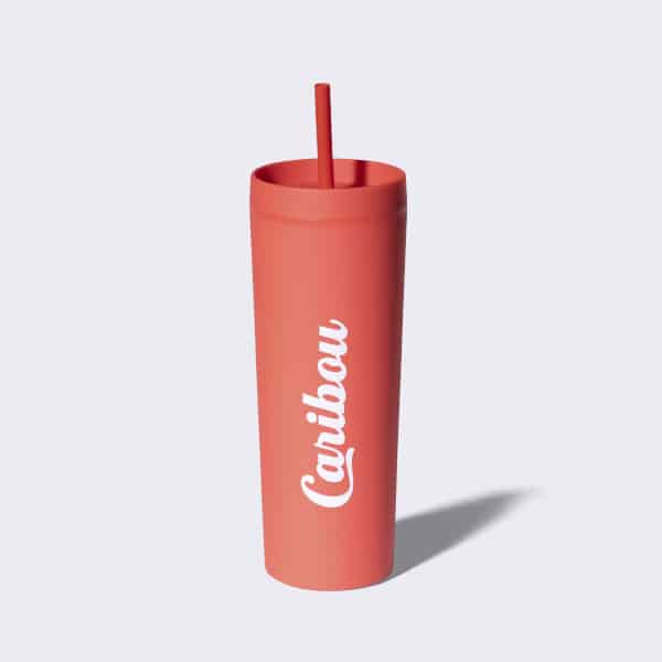 Coral silicone straw tumbler with Caribou writing.