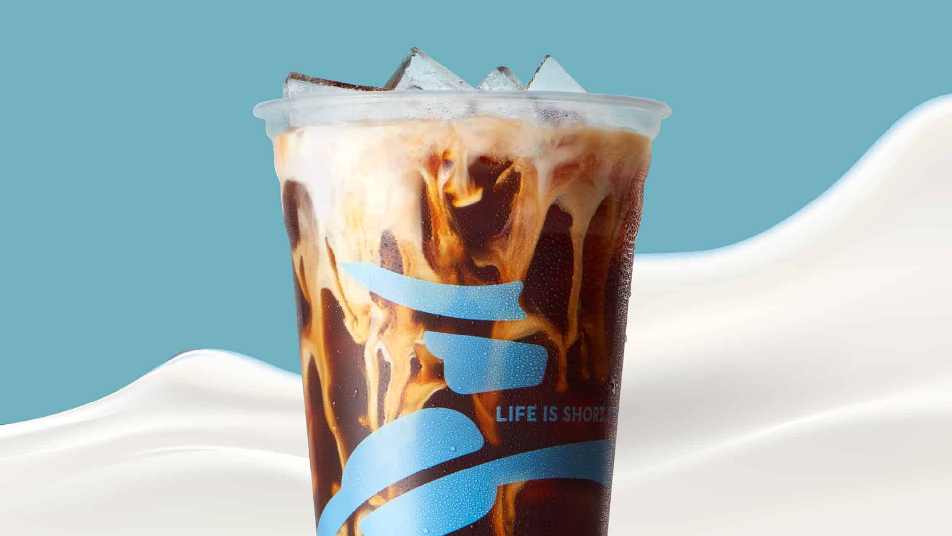 A Cold Press coffee with non-dairy milk in a Caribou Coffee cup