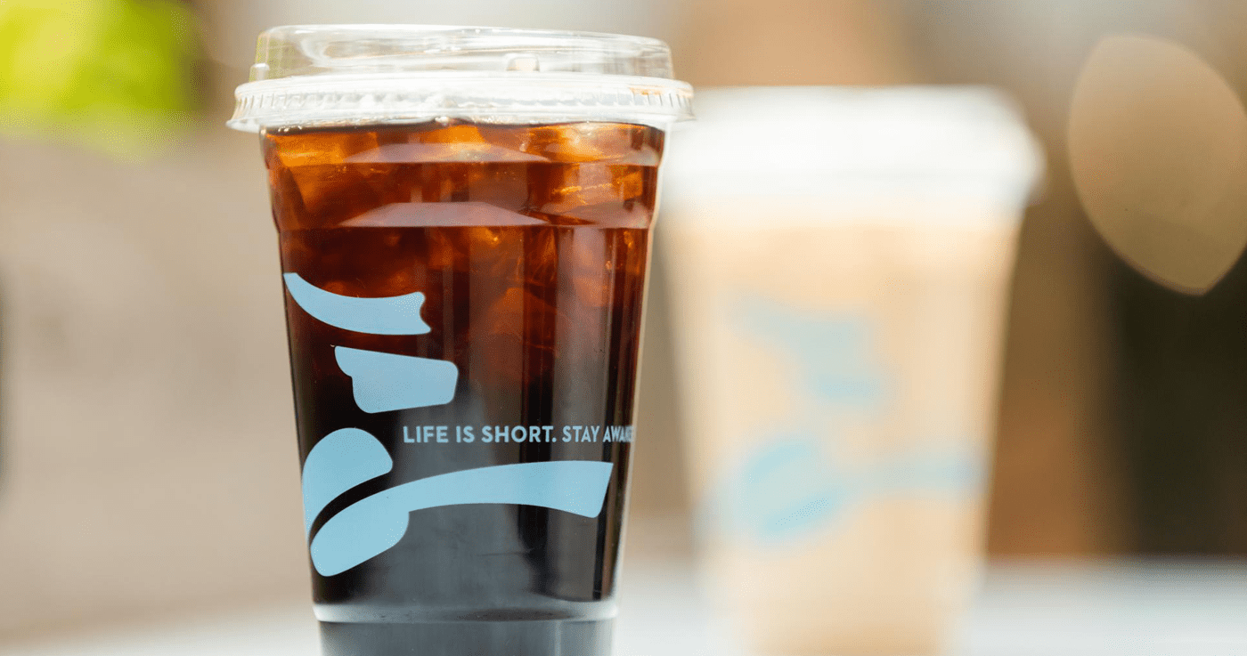caribou coffee cold press with blurred beverage in background