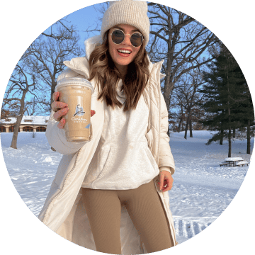 Woman smiling and holding a Caribou Coffee beverage