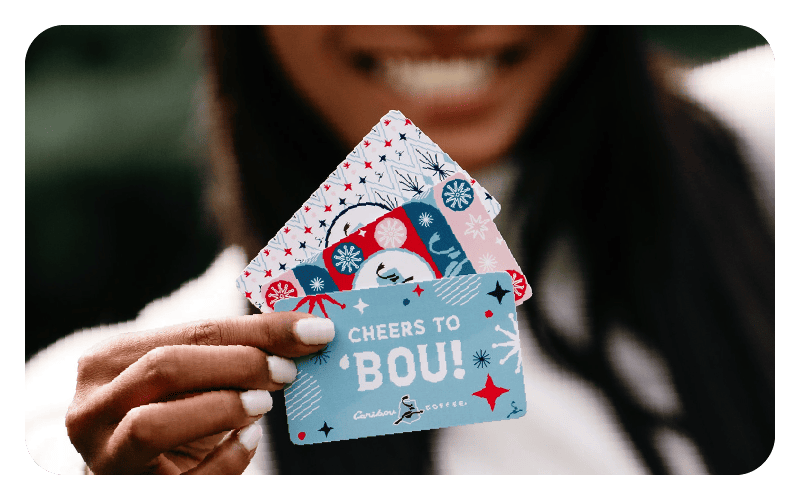 Woman smiling and holding three gift cards