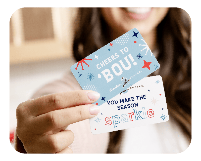 Woman holding two holiday gift cards